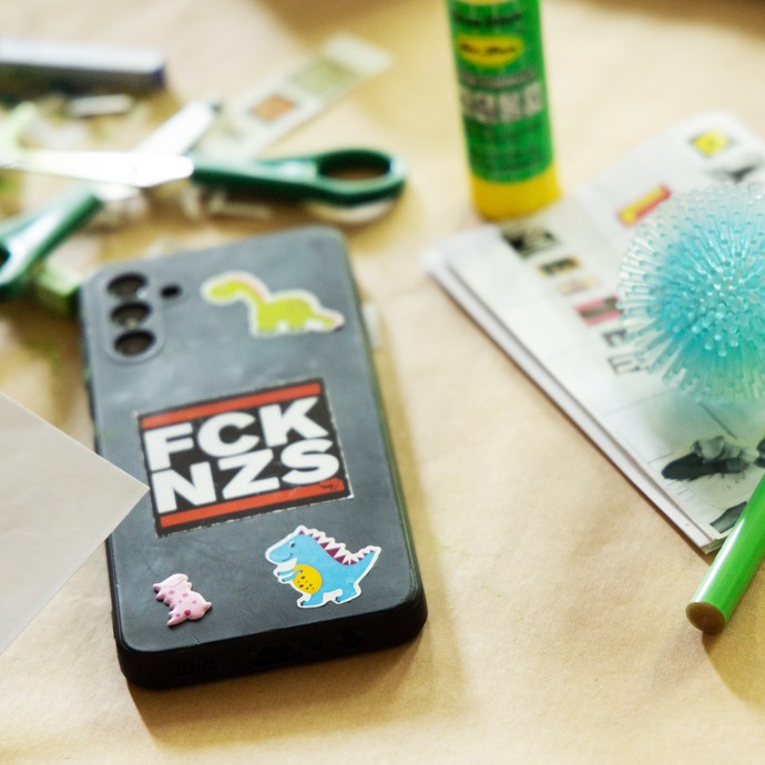 Handyhülle von hinten mit  "FCK NZS" und Bastelmaterialien im Hintergrund (vergrößerte Bildansicht wird geöffnet)