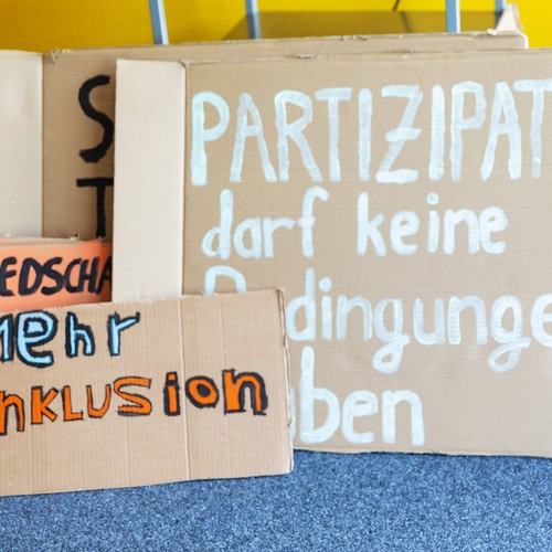 Foto von Pappschildern mit der Aufschrift "Mehr Inklusion" und "Partizipation darf keine Bedingungen haben"