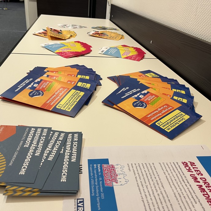 Verschiedene Flyer sind auf einem Tisch ausgelegt. (vergrößerte Bildansicht wird geöffnet)