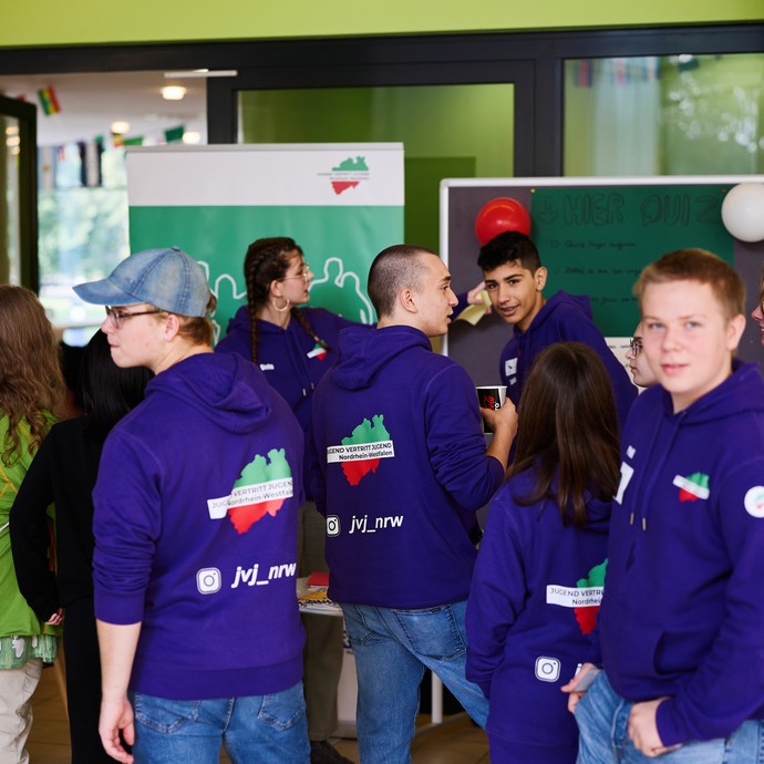 Jugend vertritt Jugend (JvJ NRW) begrüßt an ihrem Stand die Teilnehmenden. (vergrößerte Bildansicht wird geöffnet)