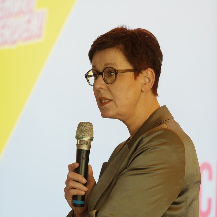Das Bild zeigt Frau Westers mit einem Mikrofon in der Hand (vergrößerte Bildansicht wird geöffnet)